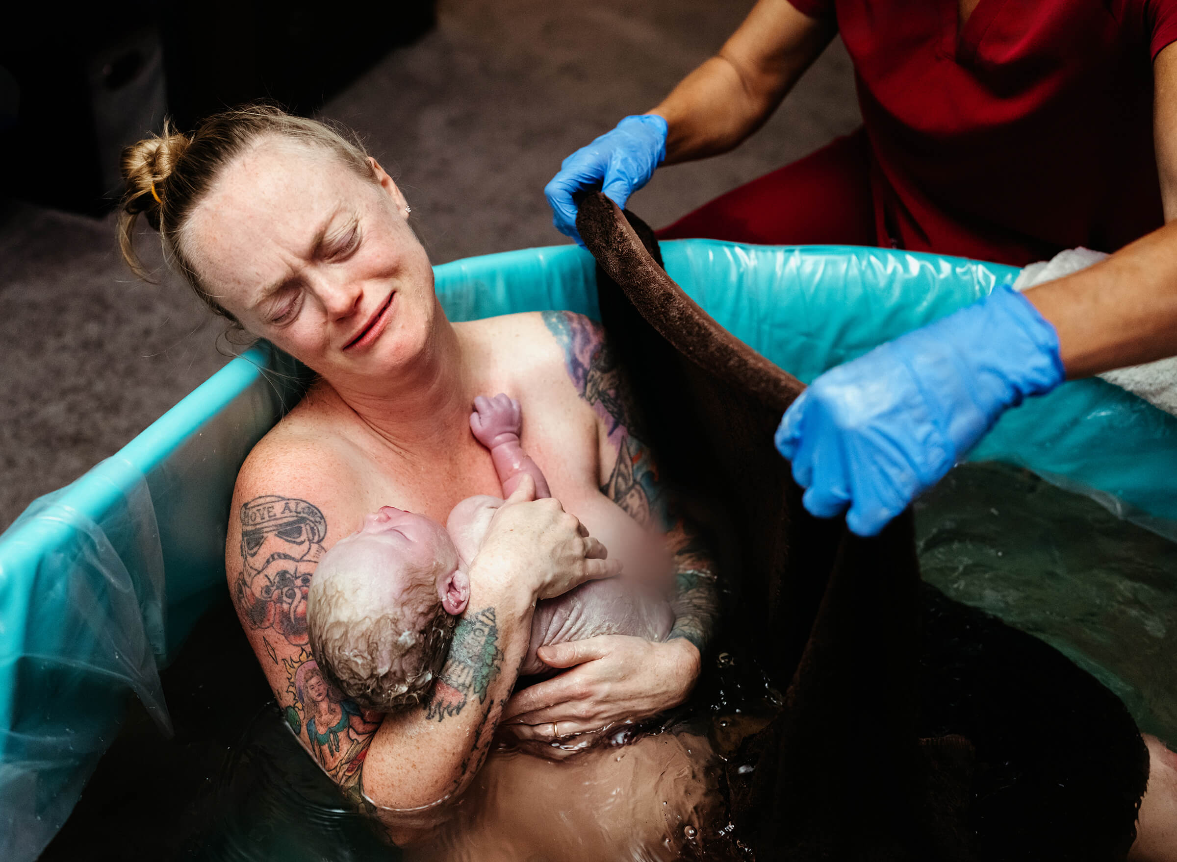 woman holding her newborn baby to her chest right after delivery