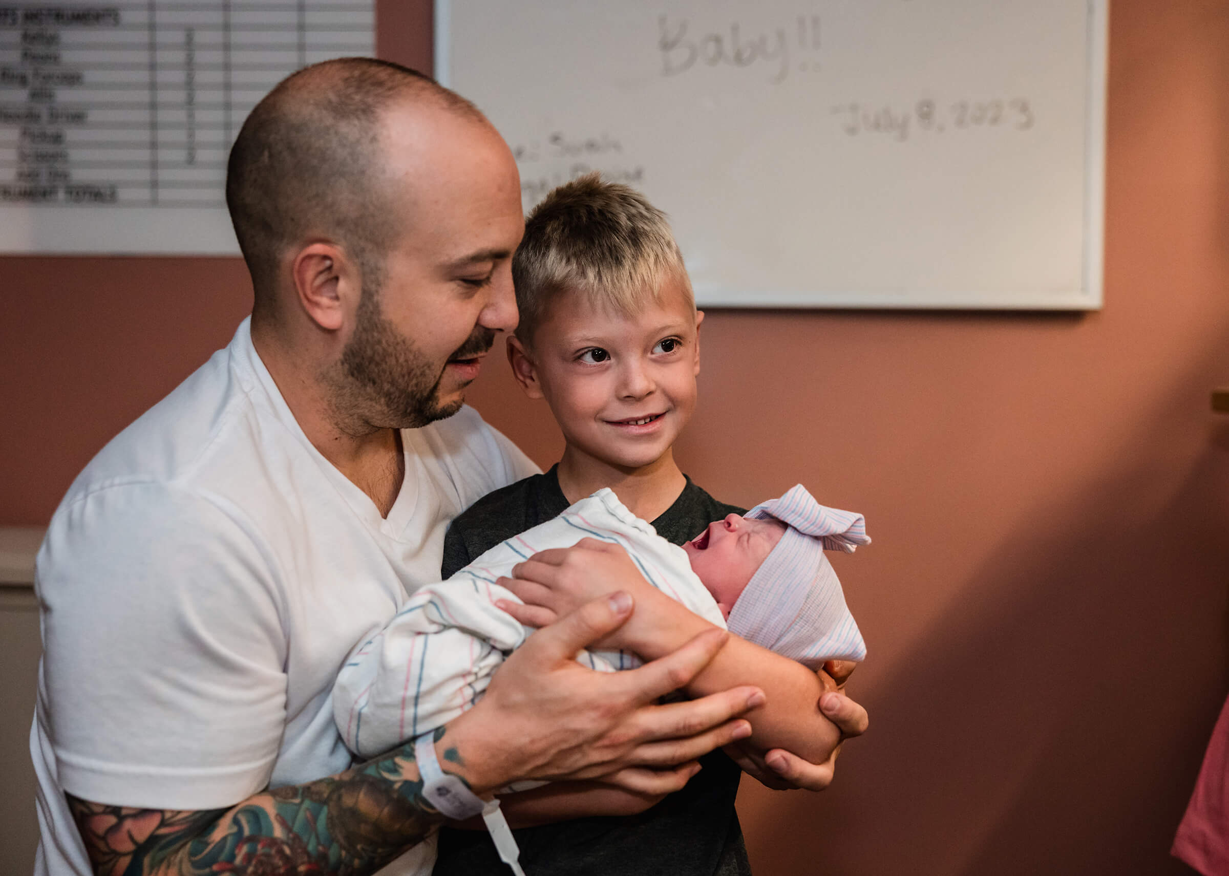 big brother holding his sister in the hospital after delivery. 