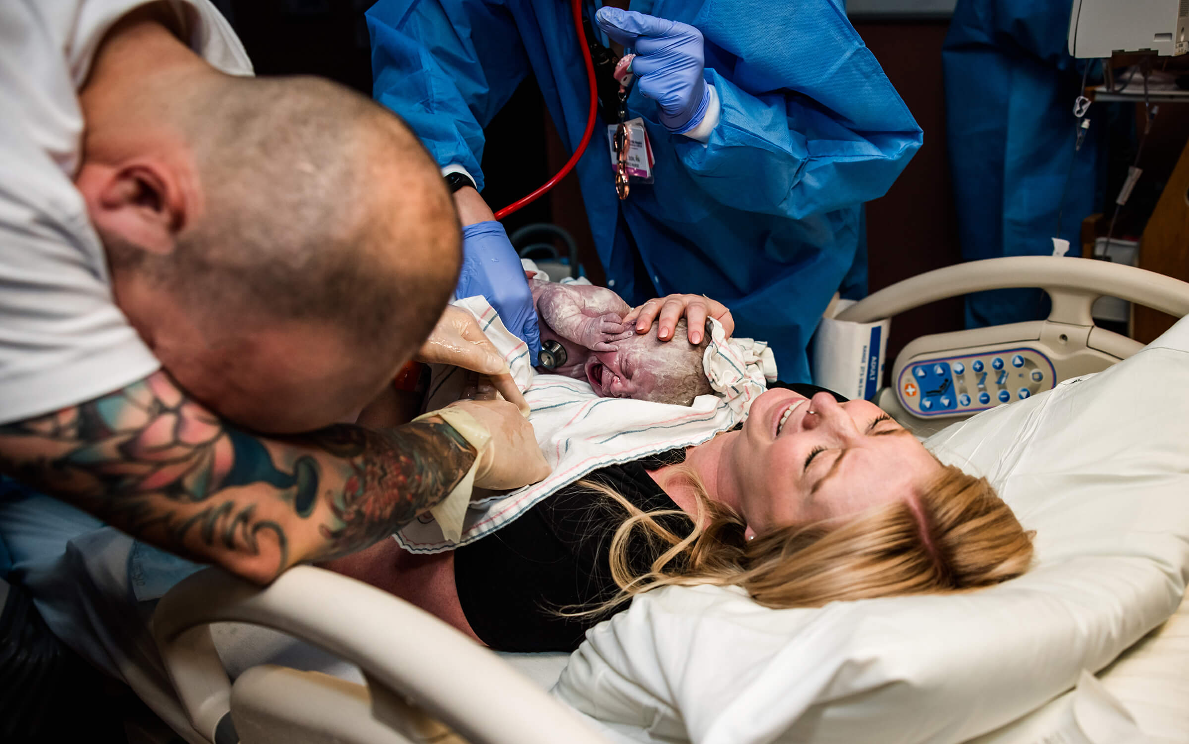 mother holding her baby close to her chest as she cries tears of joy after a hospital delivery.