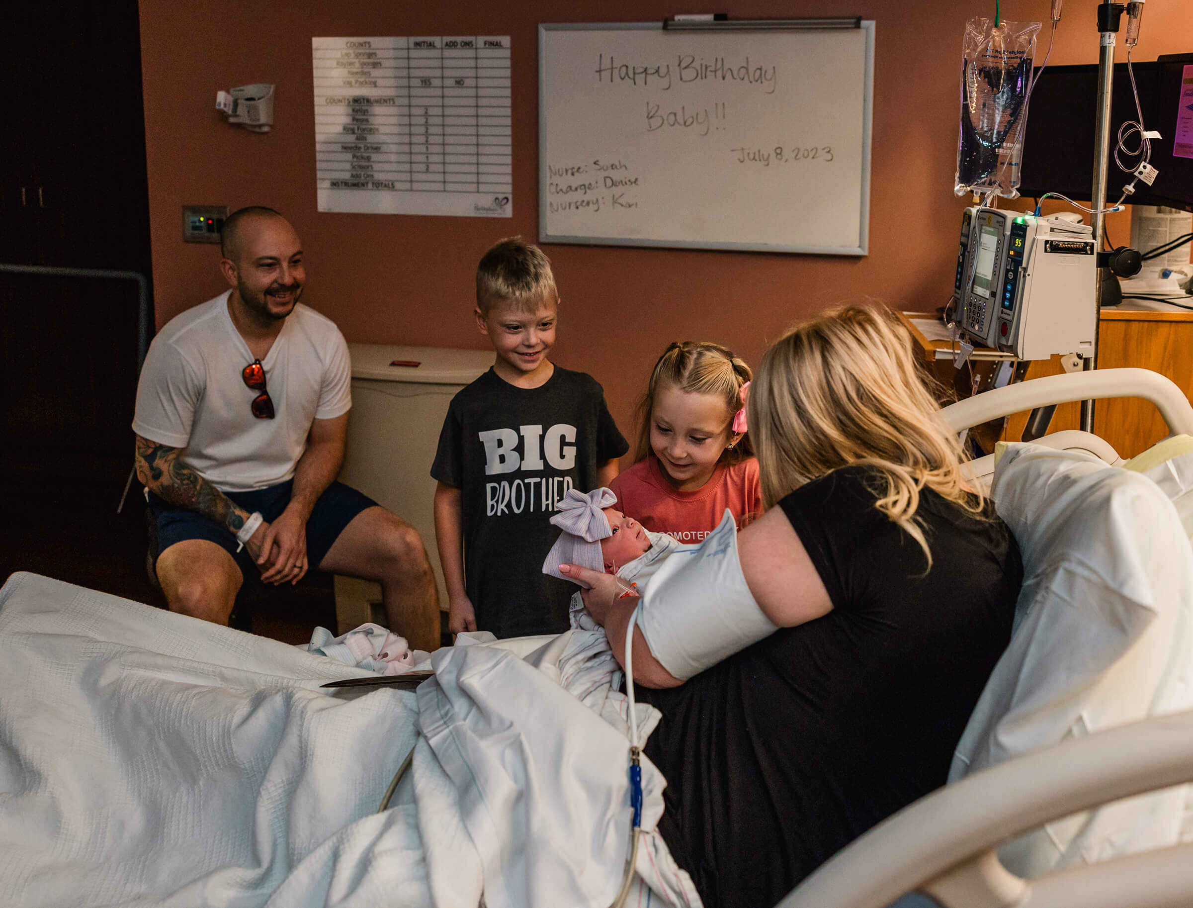 siblings being introduced to their new baby sister after a hospital birth. 