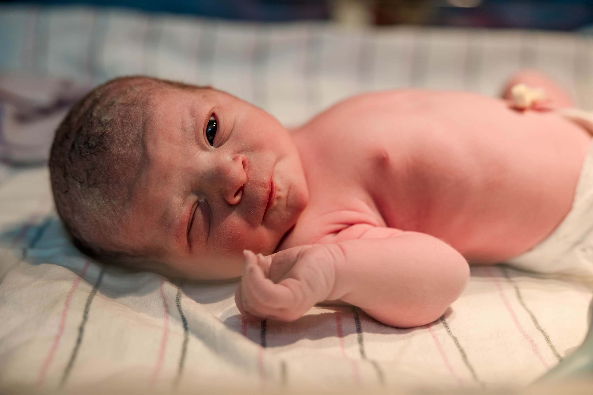 close up image of a baby in the radiant warmer with her eyes open following birth