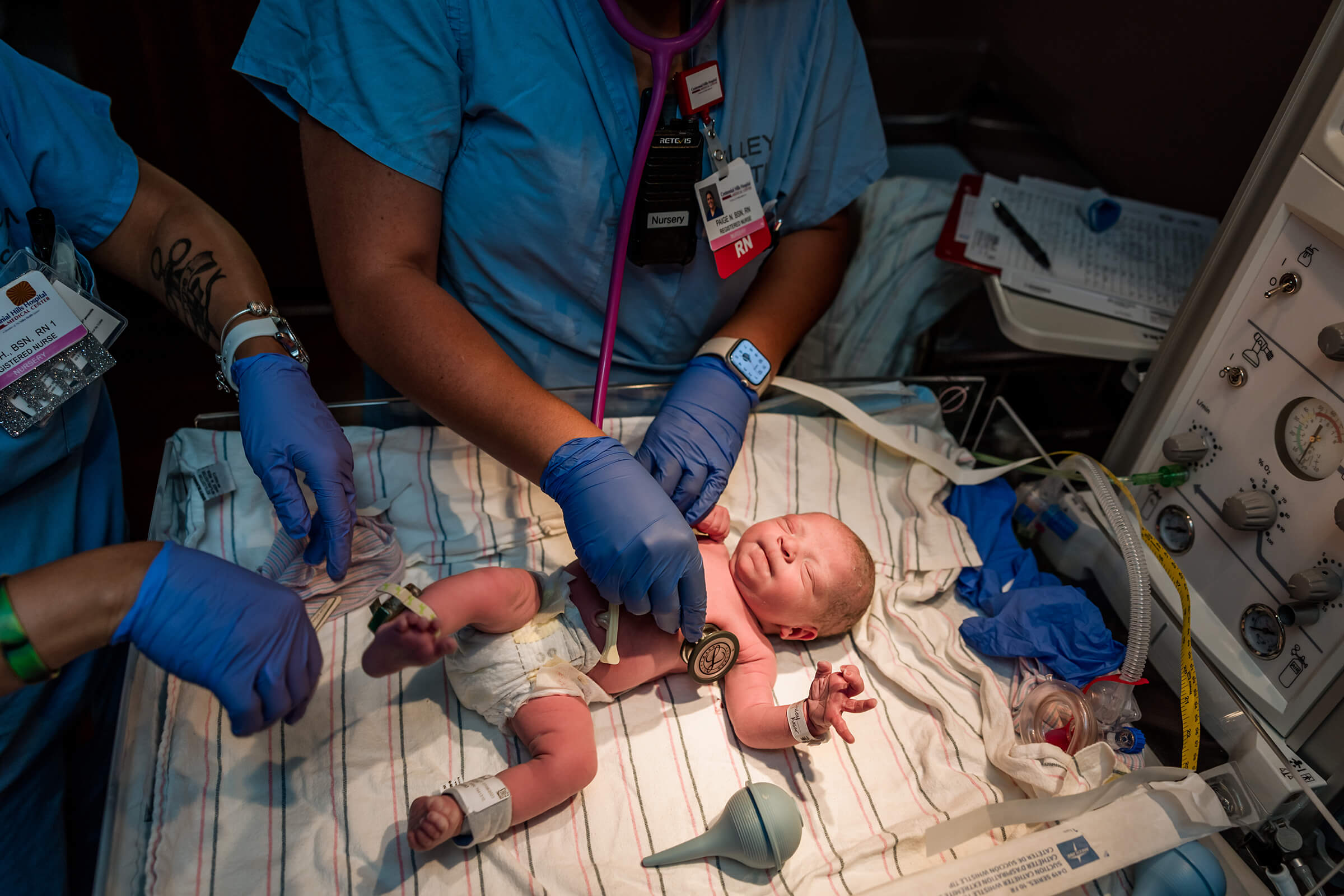 a nursery nurse checking a new baby's heart rate and lung sounds after a hospital birth