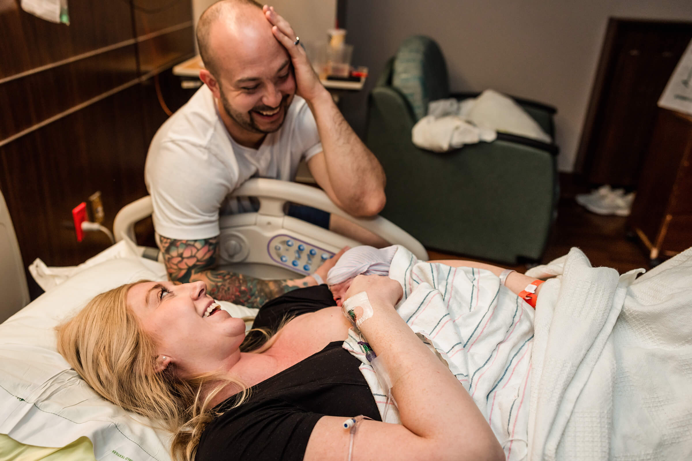 an image from the side of a labor bed as both parents experience the emotions following birth