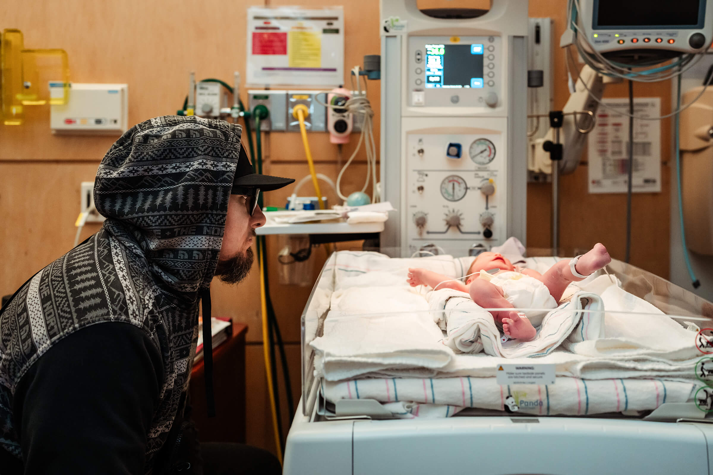 dad at warmer as twin B is warmed post delivery