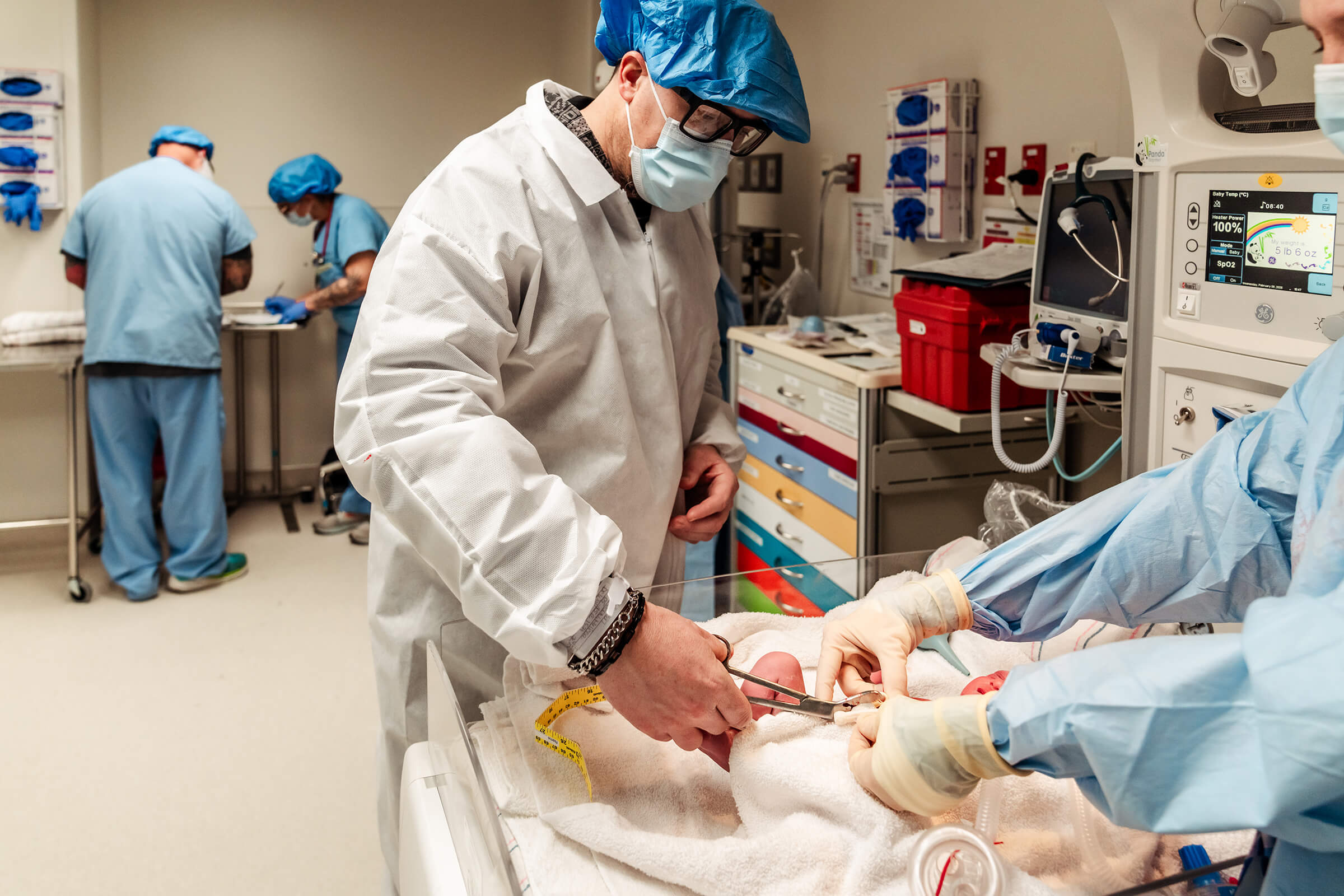 father cutting remaining cord after c-section