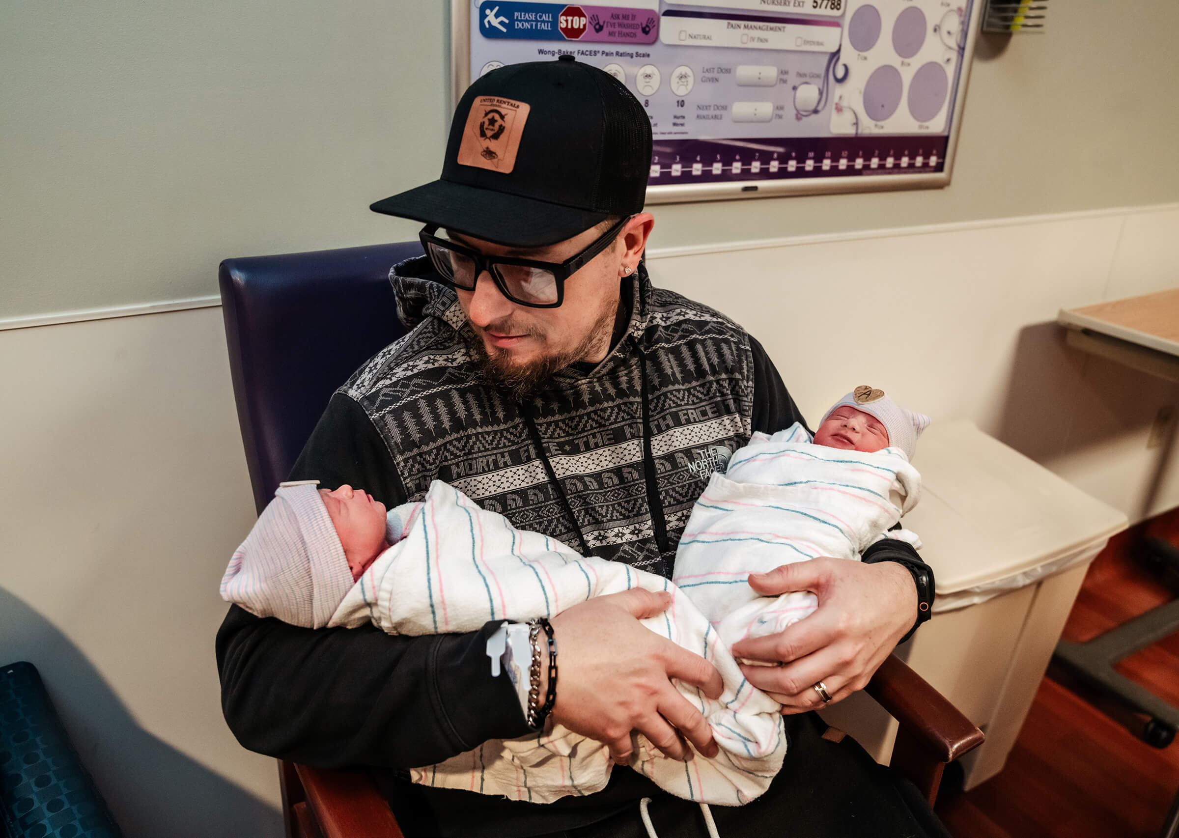 father holding his twin girls for the first time in the recovery room
