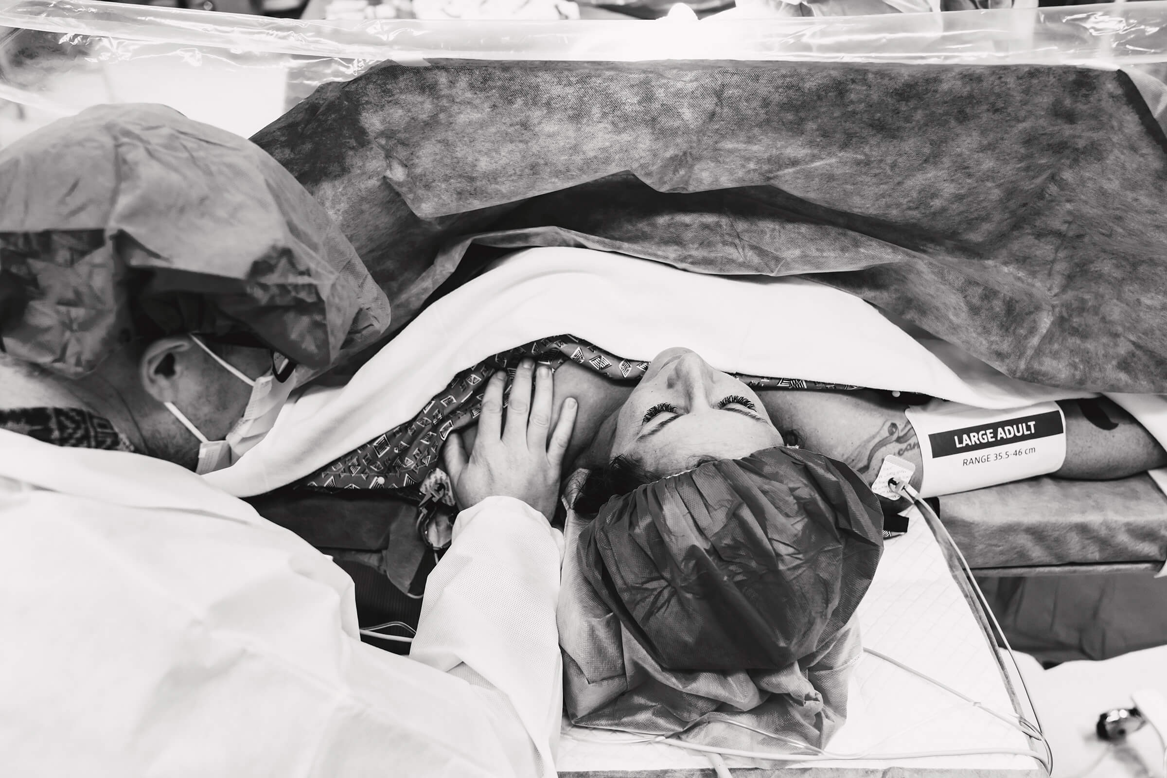 the power of faith, hope, and love as a father covers his wife in prayer in operating room