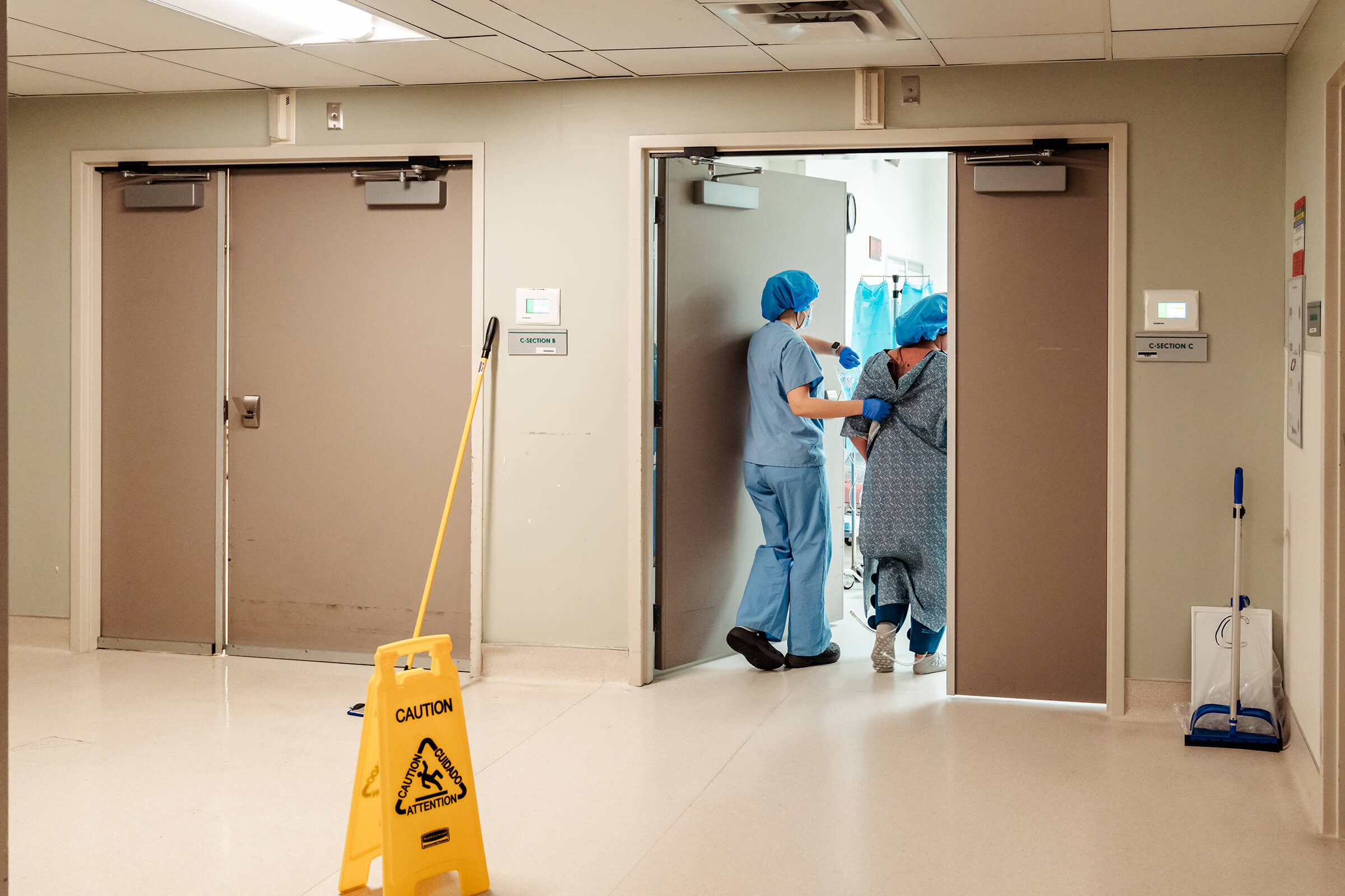 mother walking into the operating room accompanied by nurse before delivery of twins