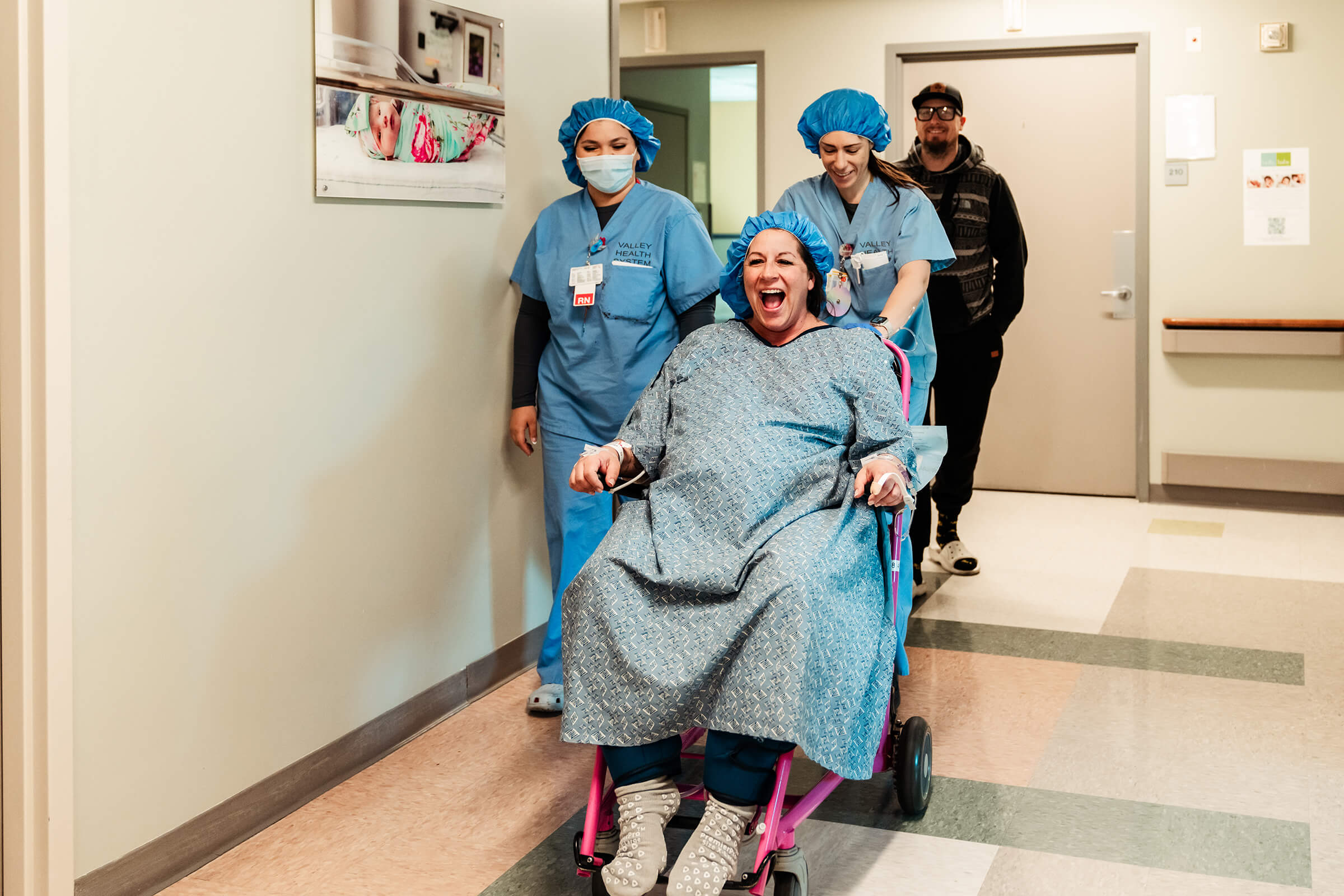 a mother in a wheelchair as they wheel her to the operating room for a c-section