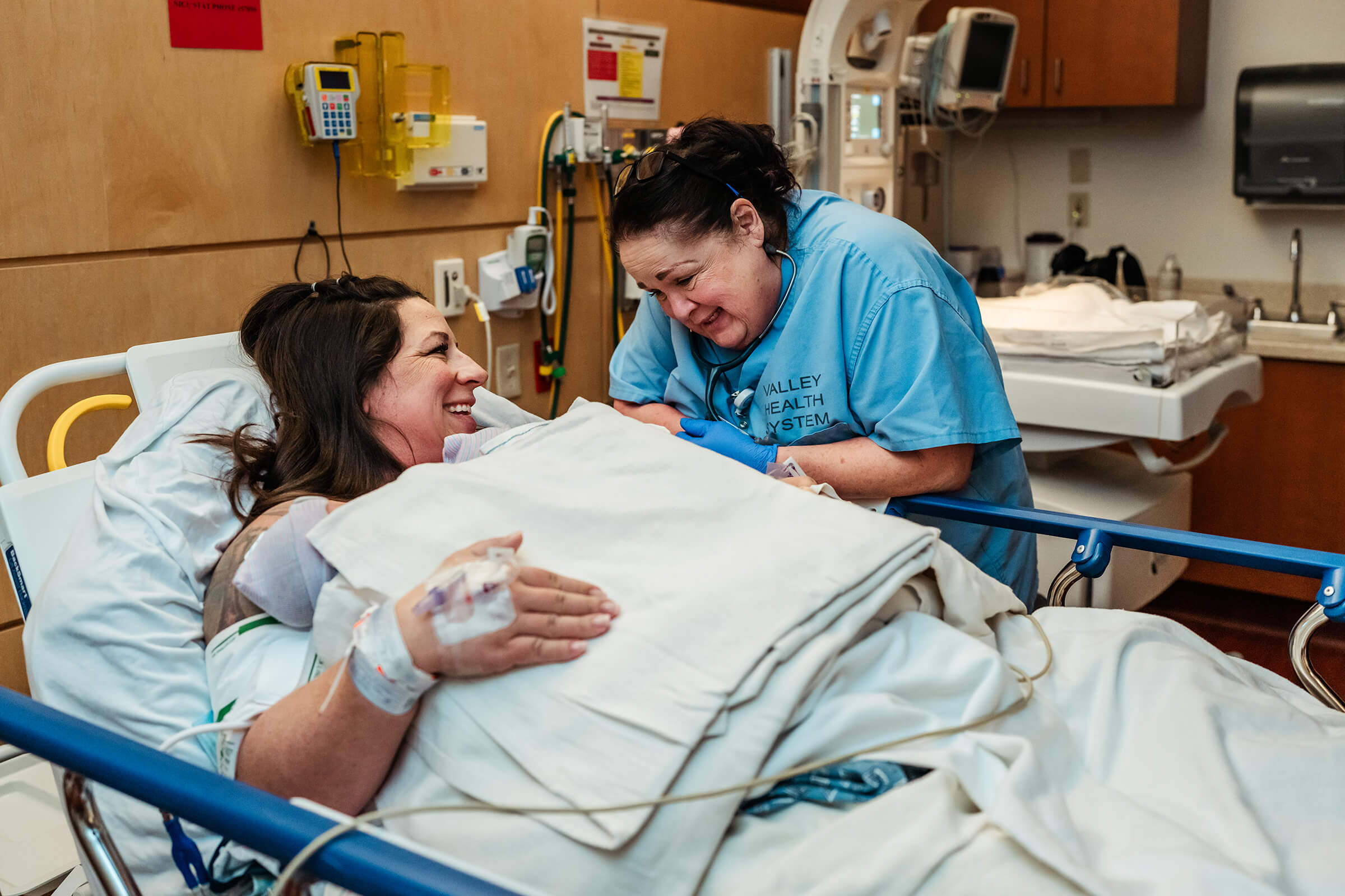 nurse at bedside as mom holds her twin girls skin-to-skin