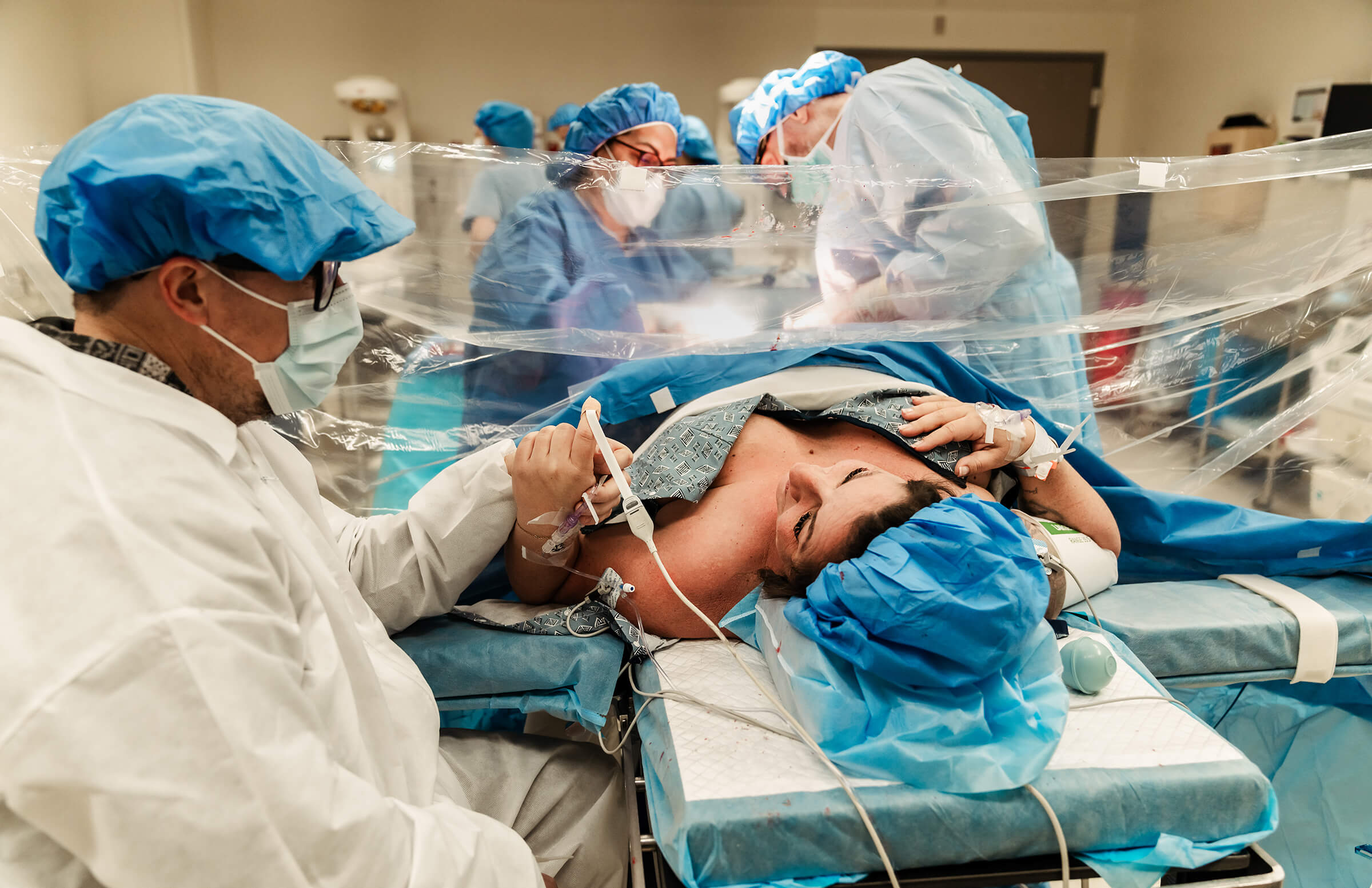 parents holding hands as their doctor begins surgery for a gentle cesarean