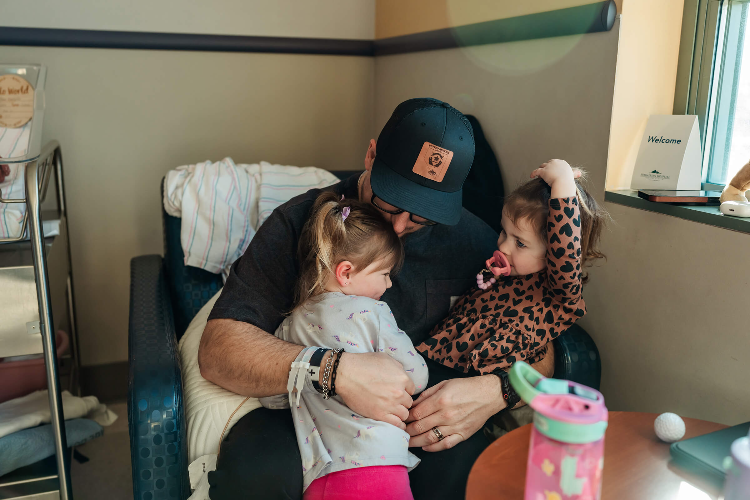 Dad embracing two of his 6 daughters